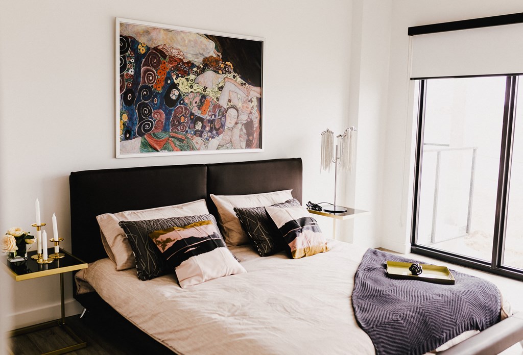 a bedroom with a bed and a painting on the wall