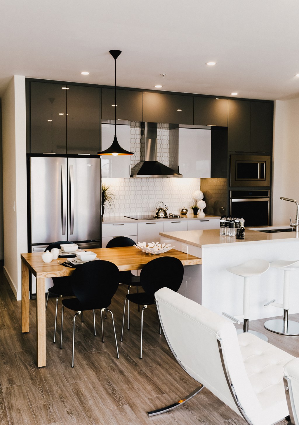 a kitchen and dining area with black and white appliances and a wooden table