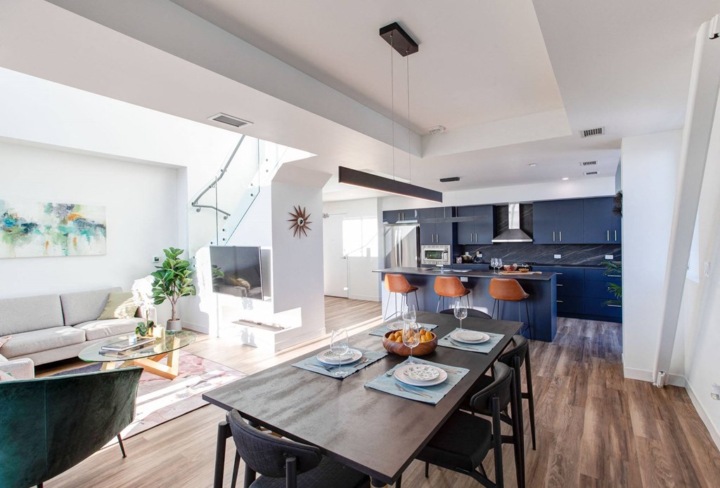 a living room and dining room with a table and chairs