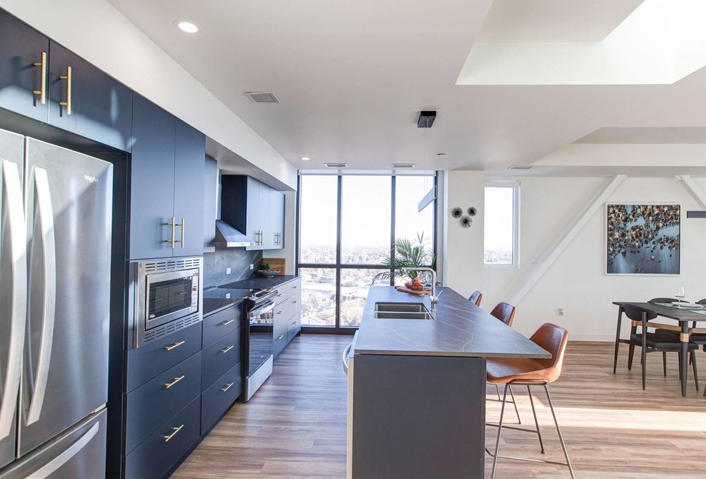 a large kitchen with blue cabinets and a table and chairs