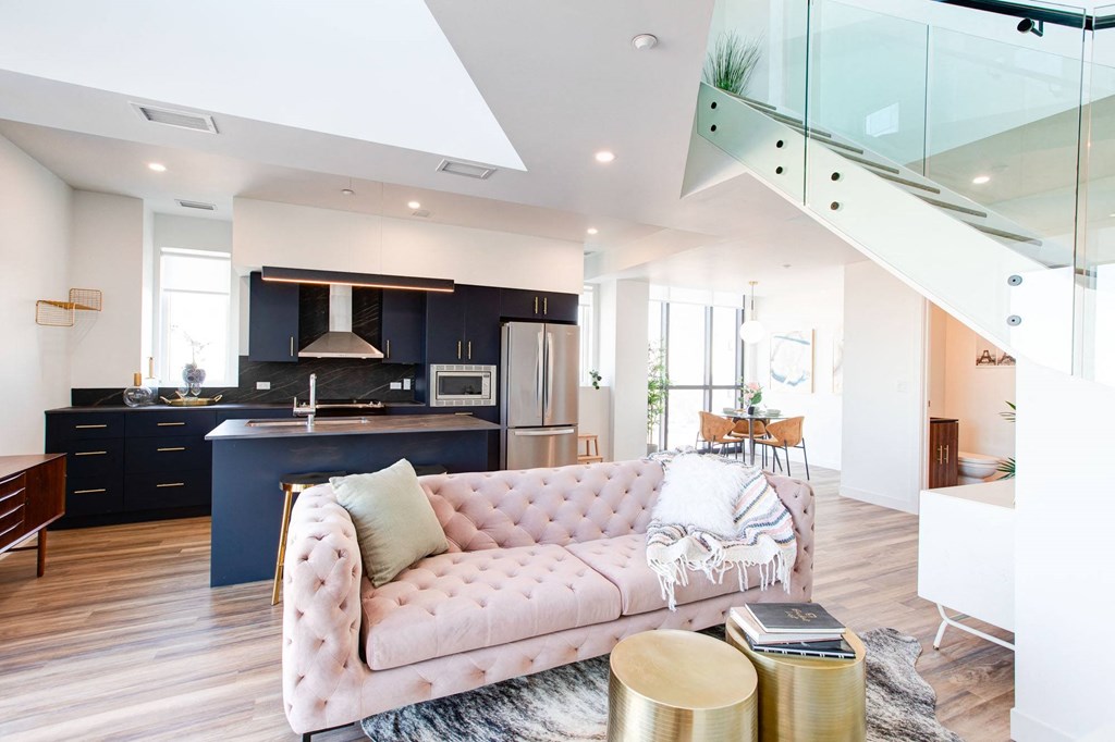 a living room and kitchen with a pink couch