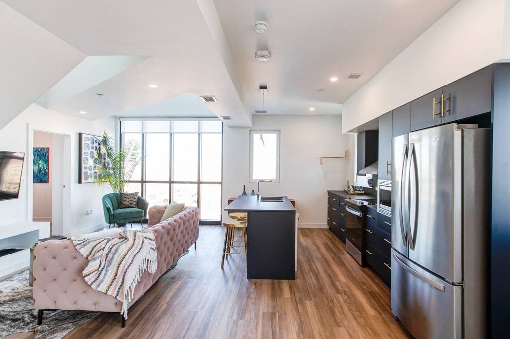 a kitchen and living room with a stainless steel refrigerator