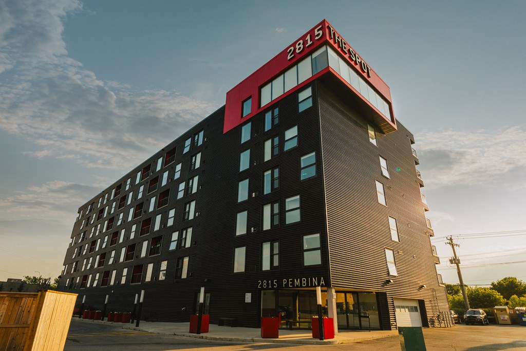 a tall building with a red and black sign on top of it