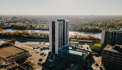 an aerial view of a tall building with a river in the background