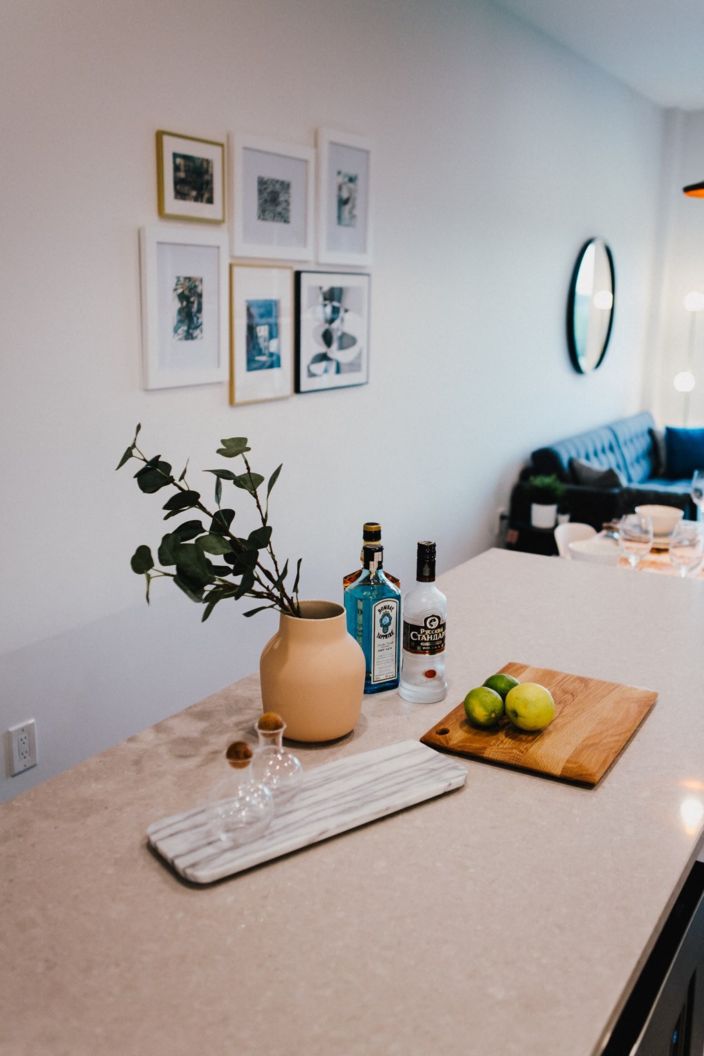 a kitchen counter with a cutting board with fruit and a bottle of wine on it