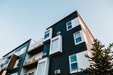 a green and white building with a sky background