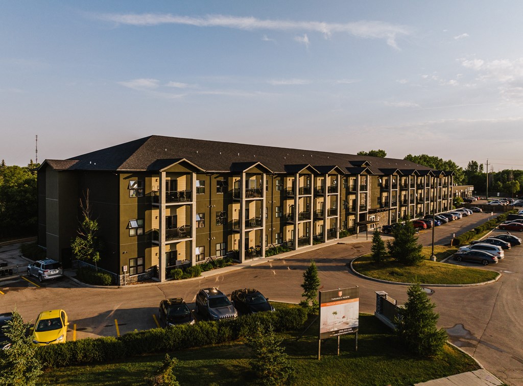 a large apartment building with a parking lot in front of it