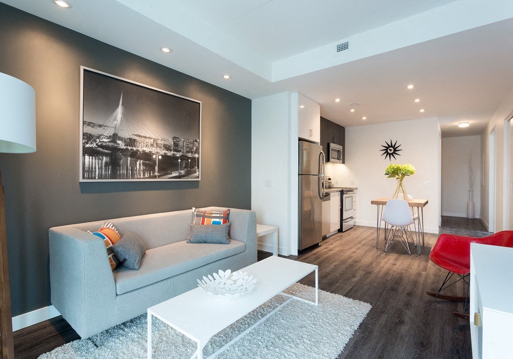 a living room with a gray couch and a white coffee table