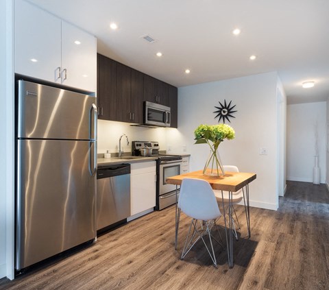 a kitchen with stainless steel appliances and a small table