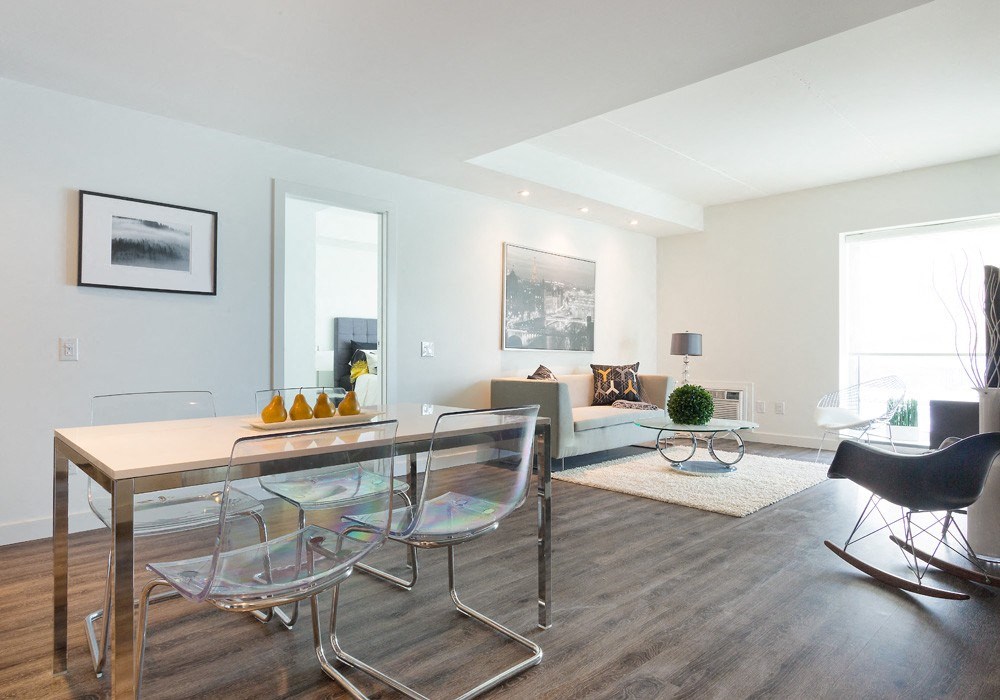 a living room with white walls and hardwood floors