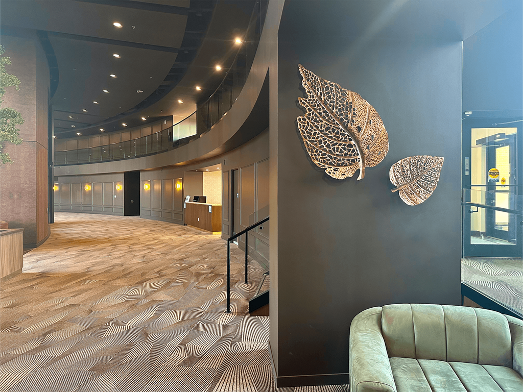 a lobby with a couch and a wall with two leaves on it