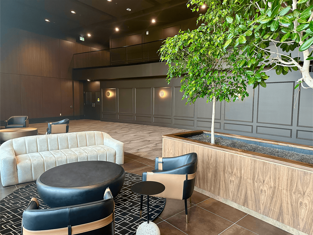 a lobby with couches and chairs and a tree