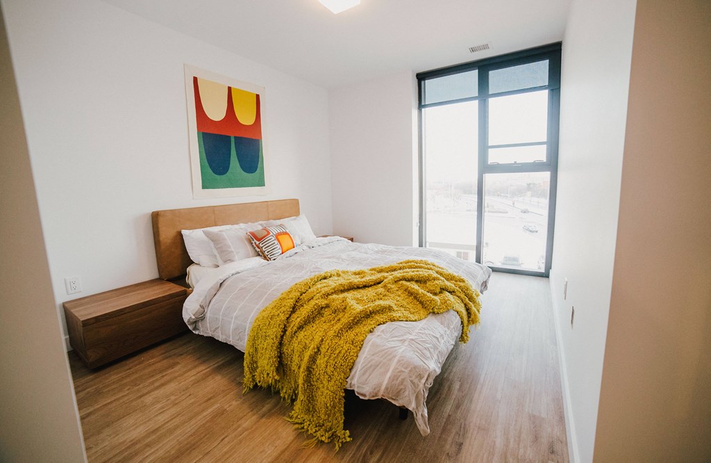 a bedroom with a bed and a large window