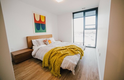 a bedroom with a bed and a large window
