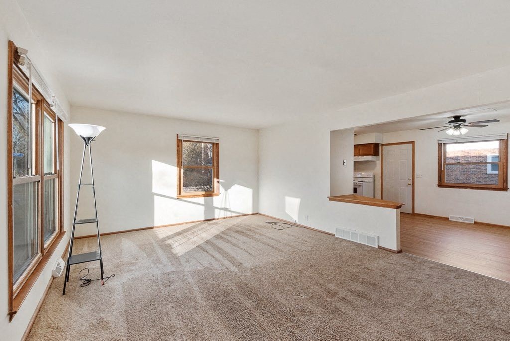 an empty living room with a ladder in front of a window