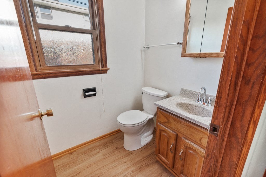 a bathroom with a toilet and a sink and a window