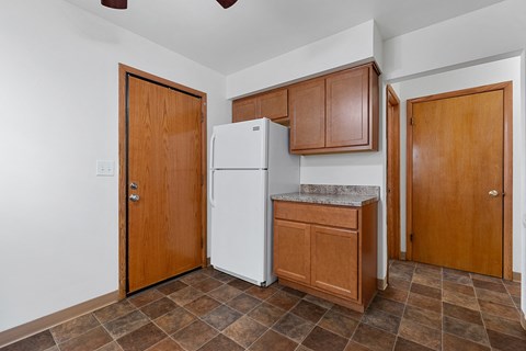 a kitchen with a refrigerator and cabinets and a door