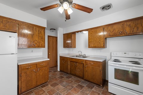 a kitchen with white appliances and wooden cabinets