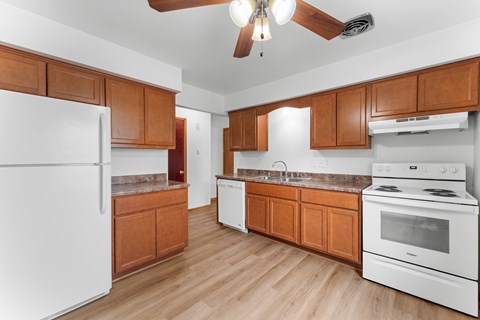 A kitchen with wooden cabinets and white appliances.