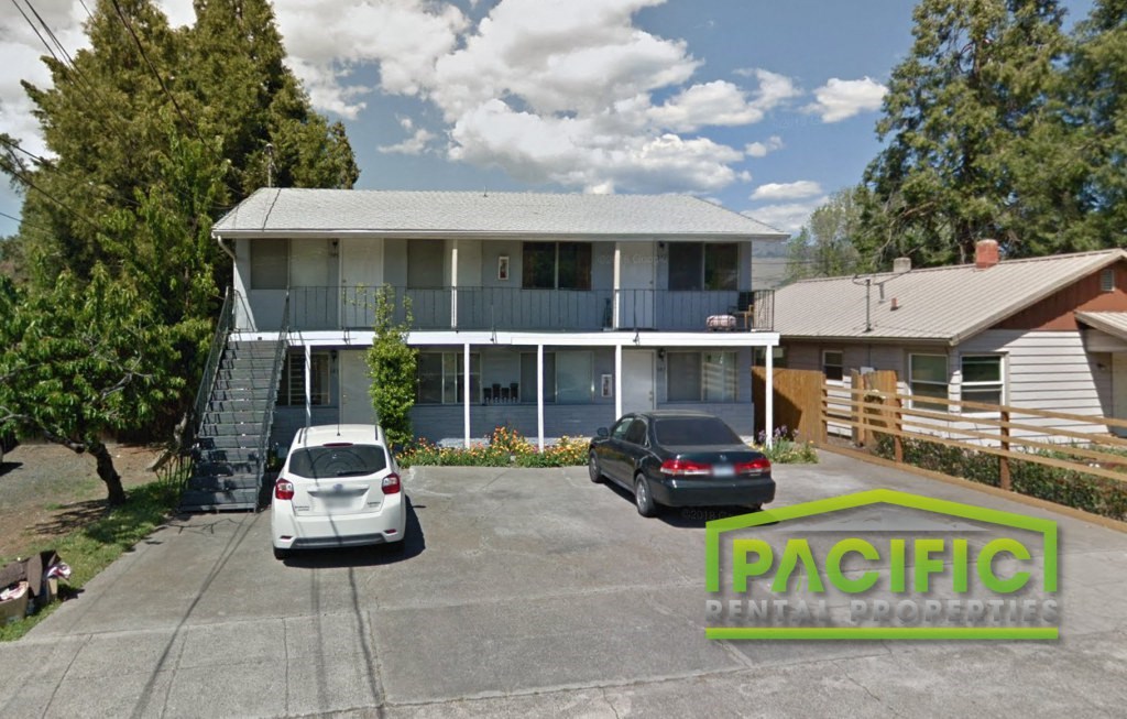 a house with a parking lot and cars in front of it