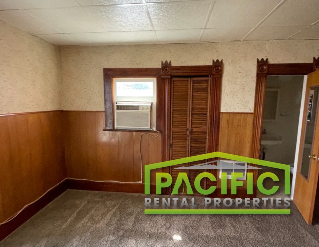 an empty room with a pacificentalental properties sign in the corner