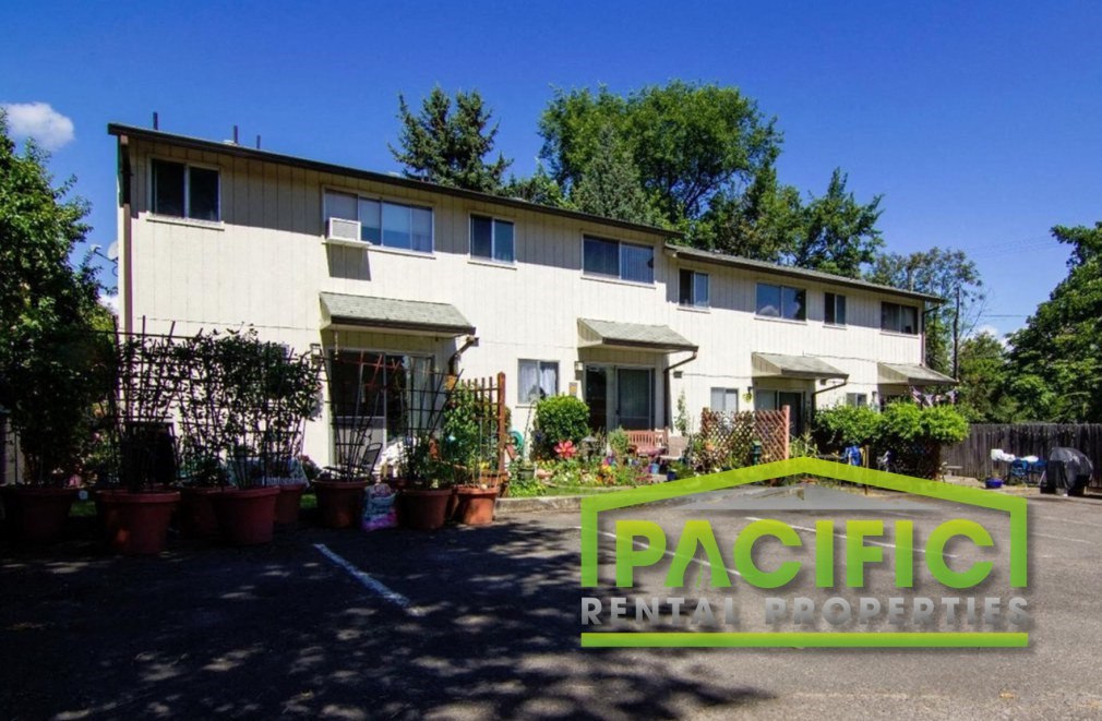 a large white house with potted plants in front of it