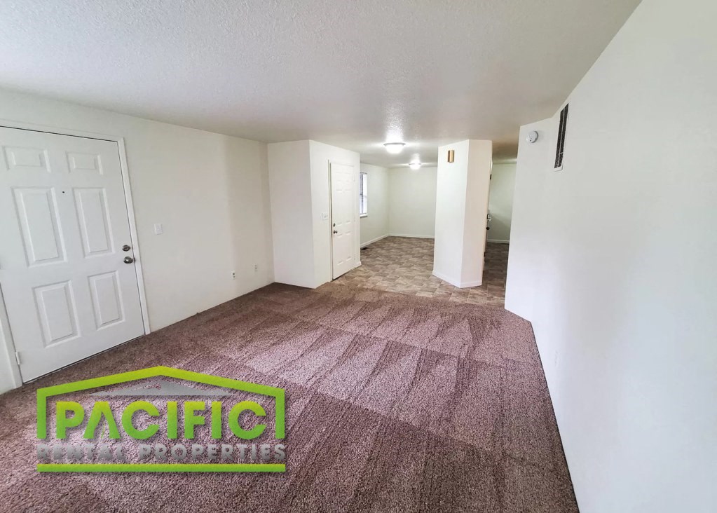 a carpeted living room with a rug on the floor