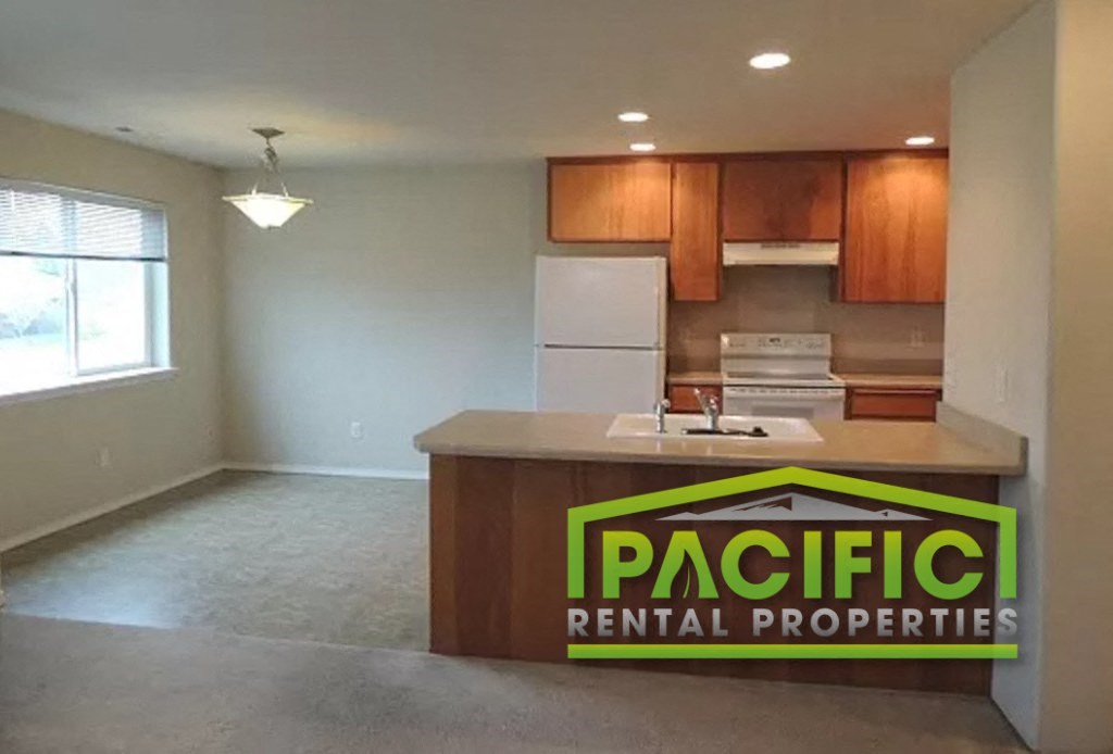 an empty kitchen with pacific rental properties logo on the counter