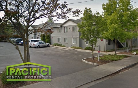 an empty parking lot in front of an apartment building