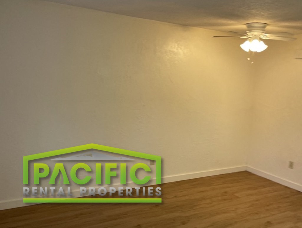 a living room with a ceiling fan and a sign on the wall
