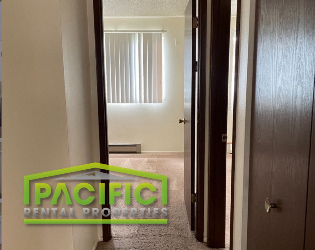 a corridor with a door to a bathroom and a closet