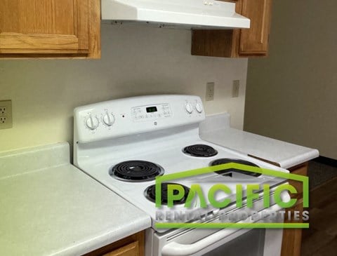 a white stove top oven in a kitchen with white counter tops
