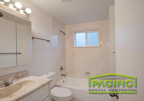 A bathroom with a toilet, sink, and bathtub.