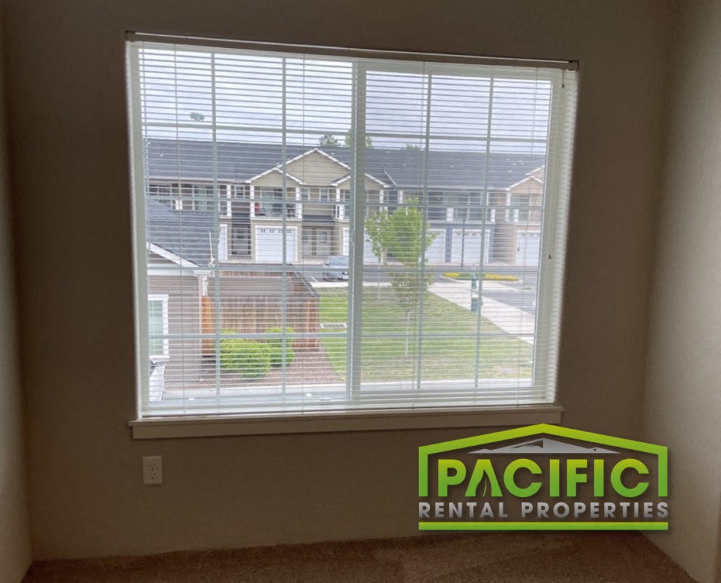 a view of a window from inside a house with a pacific rental properties logo