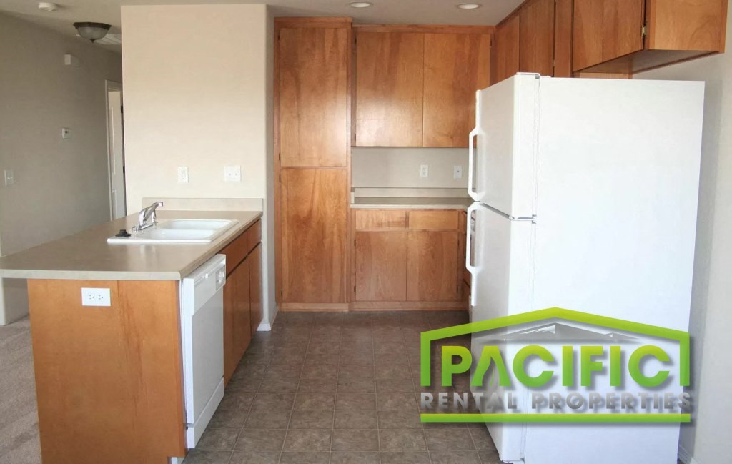 a kitchen with wooden cabinets and a white refrigerator