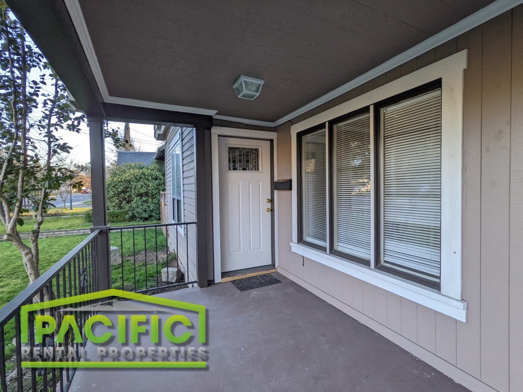the front porch of a home with a white door and windows