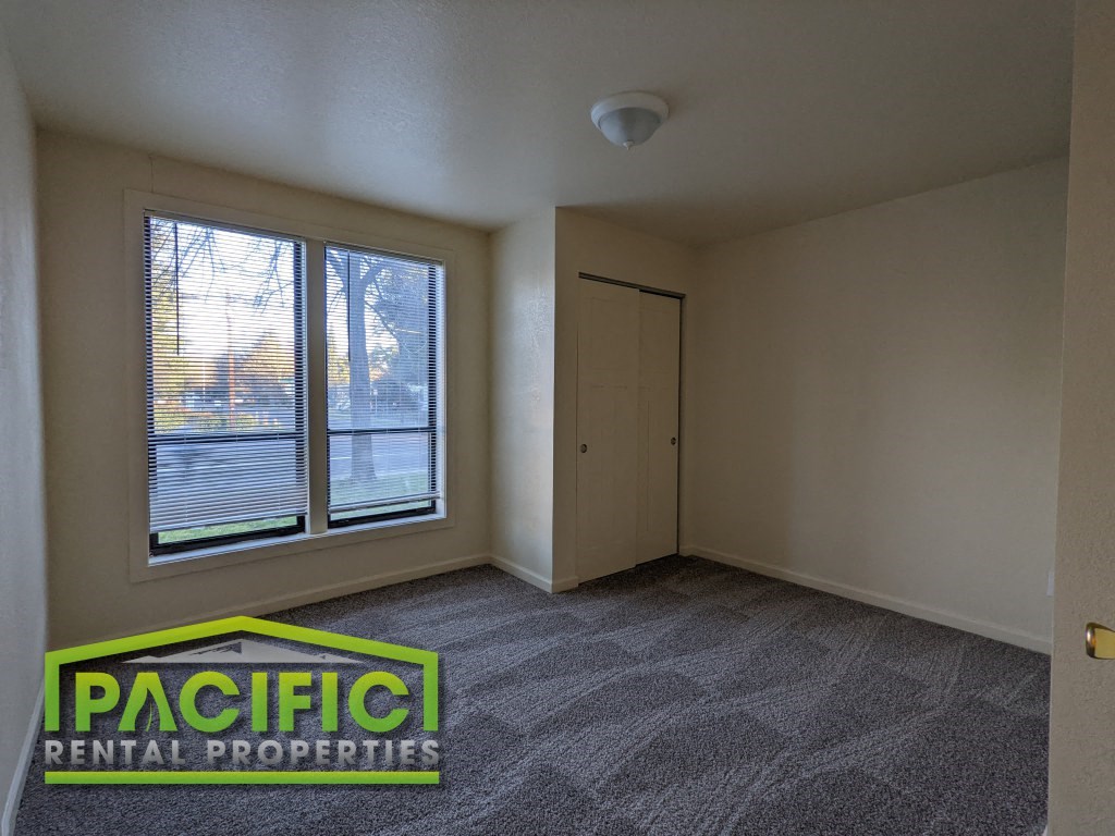 the living room of an empty apartment with a window