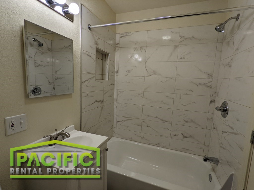 a bathroom with a shower and a sink and a mirror