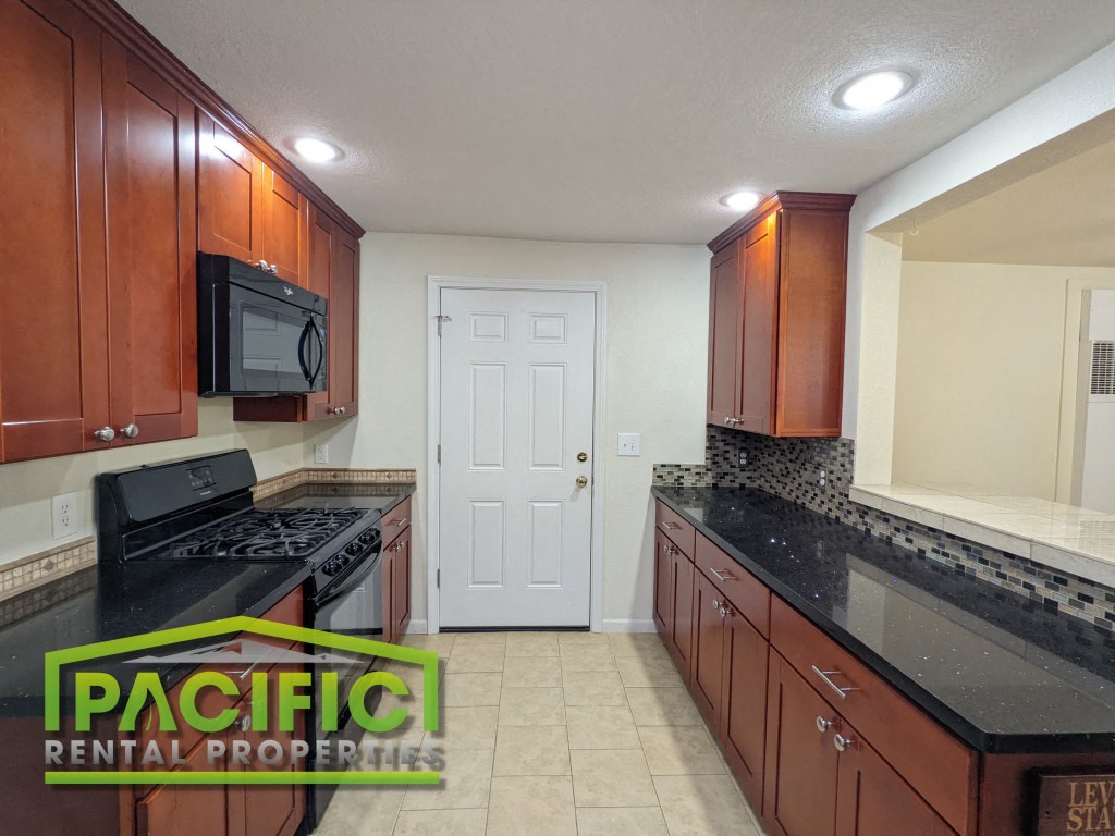 a kitchen with granite counter tops and wooden cabinets
