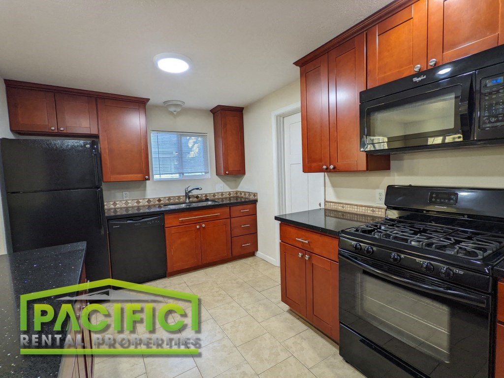 a kitchen with black appliances and wooden cabinets