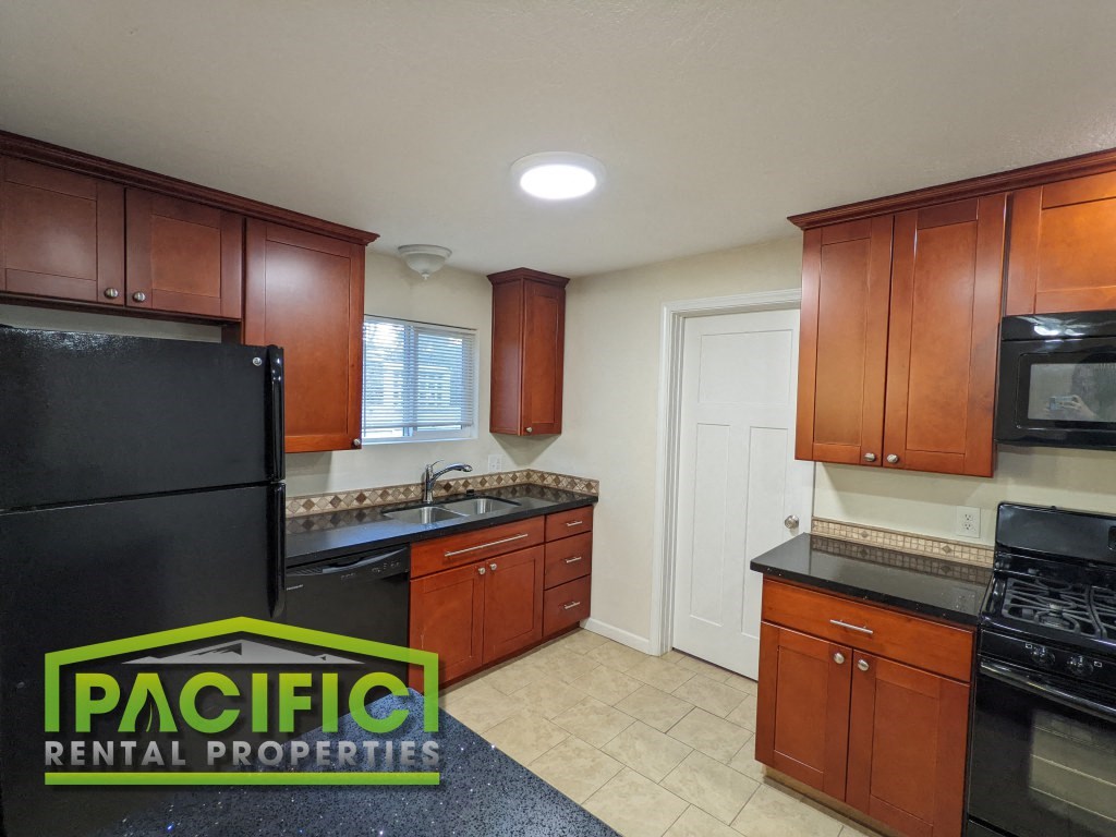 a kitchen with black appliances and wooden cabinets