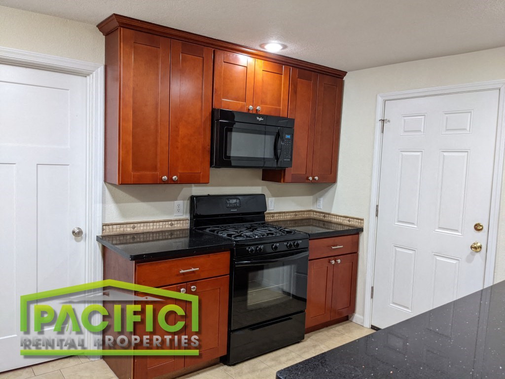 a kitchen with black appliances and wooden cabinets