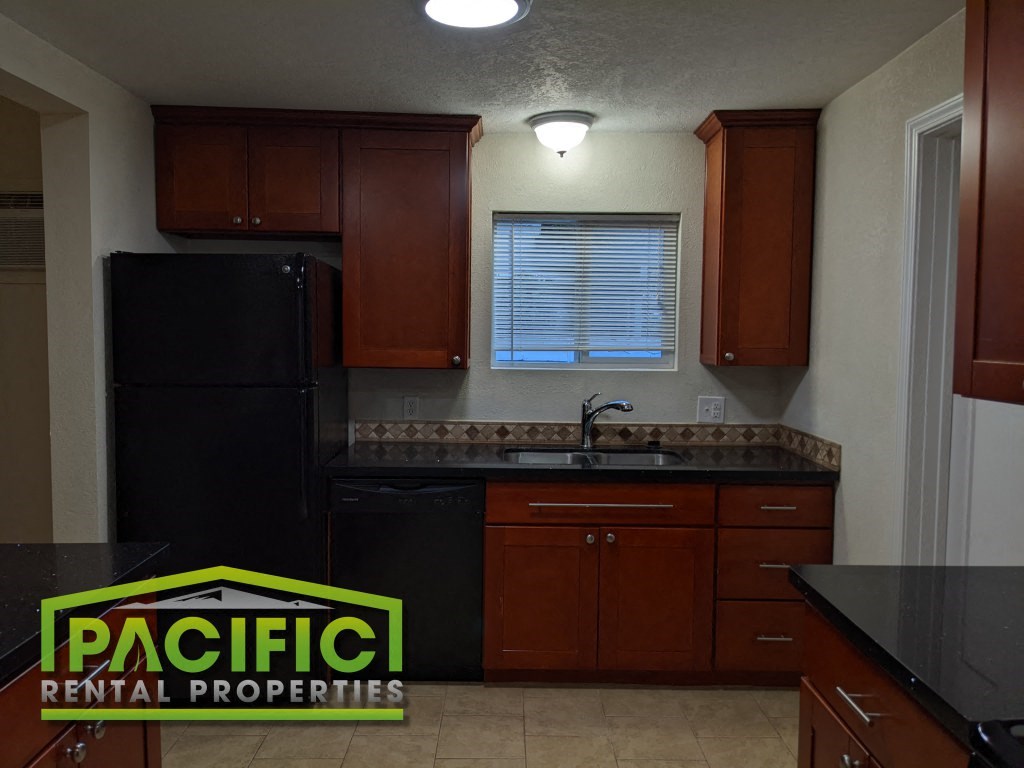 a kitchen with black appliances and wooden cabinets