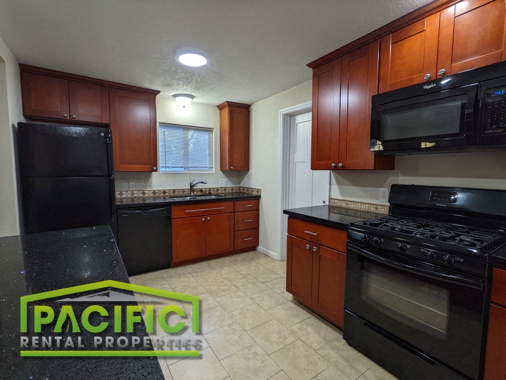 a kitchen with black appliances and brown cabinets
