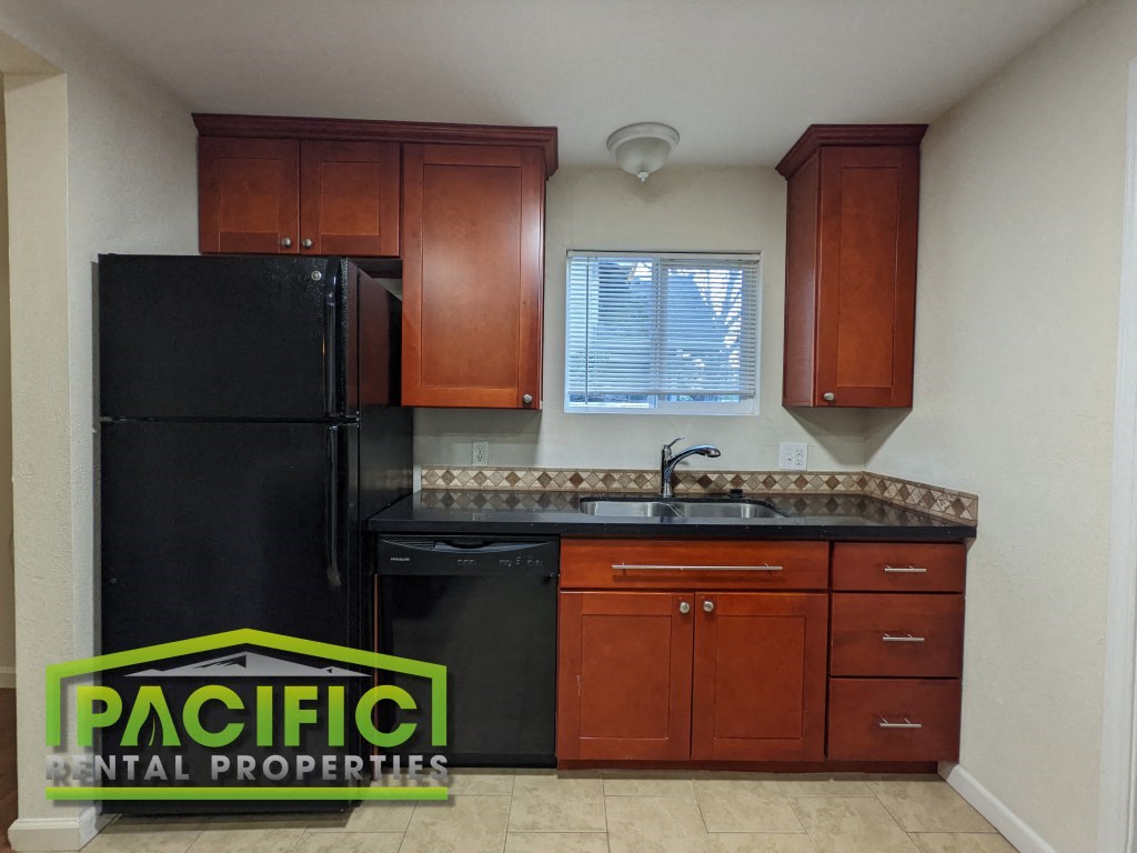 a small kitchen with black appliances and wooden cabinets
