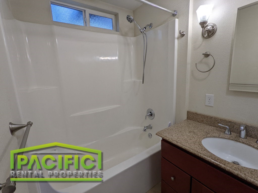 a bathroom with a shower and a sink and a mirror