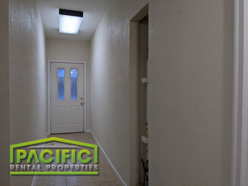 an empty hallway with a white door and a plasticentent properties logo