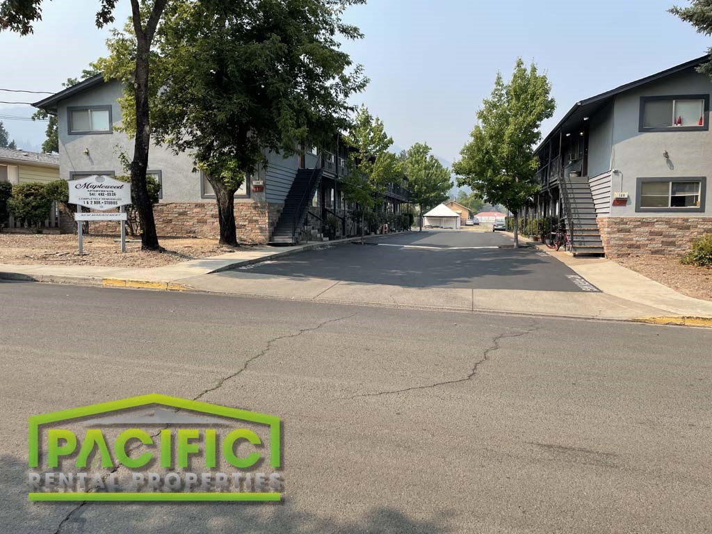 an empty street in a neighborhood with houses and trees