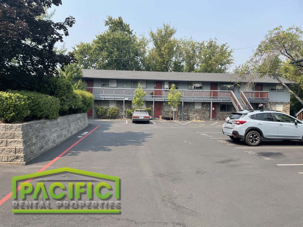a parking lot with cars in front of a motel