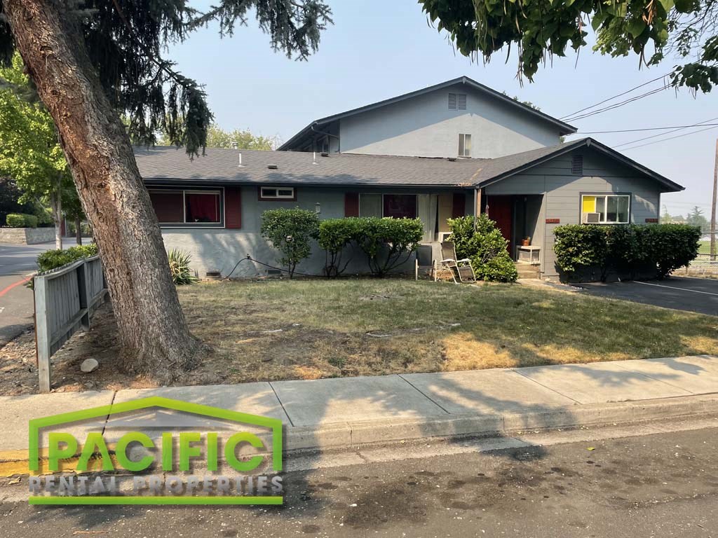 a house with a yard and a tree in front of it